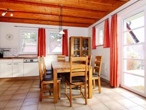 特拉森海德Apartment in Trassenheide with sauna的一间带木桌和椅子的用餐室