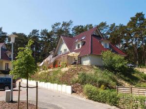 特拉森海德Apartment in Trassenheide with sauna的山坡上一座红色屋顶的房子
