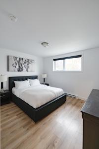 魁北克市Denis的白色的卧室设有一张大床和一个窗户