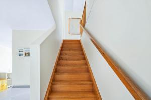 科尔斯湾蔚蓝度假屋的房屋内的楼梯,拥有白色的墙壁和木地板