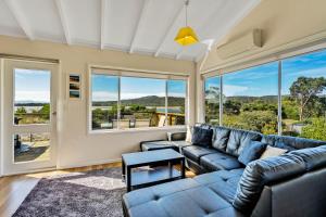 科尔斯湾蔚蓝度假屋的带沙发和大窗户的客厅