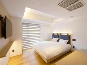 京都hotel androoms Kyoto Shichijo的卧室配有白色的床和窗户。