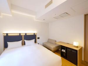 京都hotel androoms Kyoto Shichijo的一间卧室配有一张床、一张桌子和一把椅子