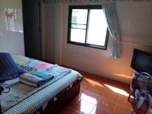 达叻府NP guesthouse的小房间设有床和窗户