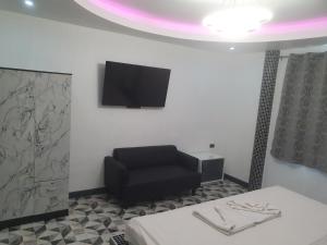 南芭堤雅时代度假酒店的一间设有黑椅和平面电视的等候室