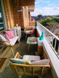 悉尼Sunny 2 bed Restaurants beach at door Pets O.K的阳台配有藤椅和桌子