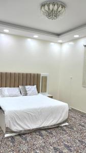 麦地那Traveler Rooms 2的卧室配有一张白色大床和吊灯。