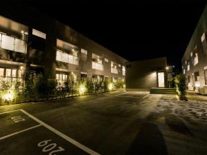 日光Rakuten STAY Nikko Hoden Capacity of 8 persons的夜间大楼前的一个空停车位