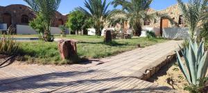 BawatiSand Rose的棕榈树建筑前的砖砌走道