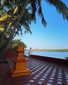 马尔万Korjai kinara Homestay的水边砖砌的露台上的橙黄色塔