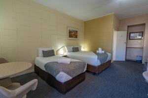 卡尔古利Hospitality Kalgoorlie, SureStay Collection by Best Western的酒店客房设有两张床和一张桌子。