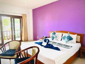 高兰Phumin Apartment的一间卧室配有一张大床和紫色墙壁