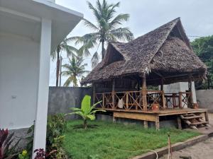 UtendeMafia Island Bungalows的棕榈树草屋顶小屋