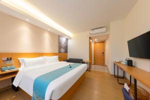 广州希岸·轻雅酒店(广州芳村花地湾地铁站店)的一间酒店客房,配有一张大床和一台平面电视
