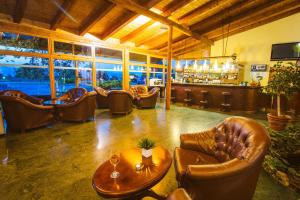 Pianu de Jos高尔夫派努酒店的一间带皮椅和酒吧的客厅