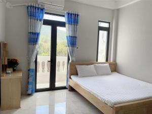 Cam LâmMoc homestay- Near Bai Dai Beach的一间卧室设有一张床和一个大窗户