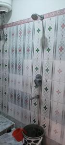 拉塔古里Hotel Sonali的浴室设有粉红色和白色壁纸,配有淋浴。
