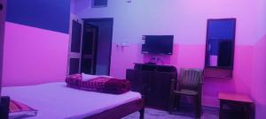 拉塔古里Hotel Sonali的粉红色的房间,配有床和电视
