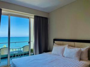 芽庄The Sea Luxury Nha Trang Apartment的一间卧室设有一张床,享有海景