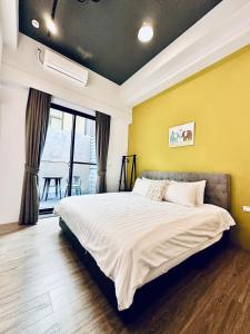 后里Mo默默旅宿的一间卧室设有一张床和黄色的墙壁