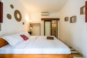 乌布Uda Suite Guest House 1的一间卧室配有一张带白色床单的大床