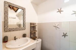 乌布Uda Suite Guest House 1的白色的浴室设有水槽和镜子