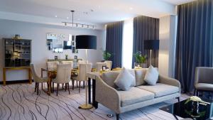 泗水Grand Swiss-Belhotel Darmo的带沙发的客厅和用餐室