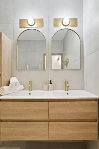 马赛Le confort d'un T3 climatisé en plein coeur de Marseille的浴室设有2个水槽和2面镜子