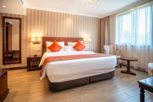 纳库鲁萨洛娃伍德兰兹Spa酒店的酒店客房配有一张带橙色枕头的大床