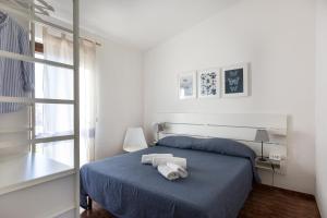 圣特奥多罗Residence il Melograno的一间卧室设有蓝色的床和窗户。