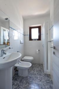 圣特奥多罗Residence il Melograno的白色的浴室设有水槽和卫生间。