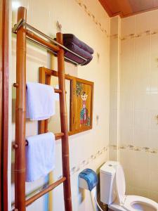 清迈泰小院儿（99 Friend’s house Lanna )的一间带卫生间和毛巾架的浴室