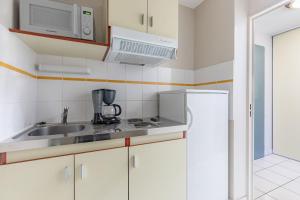 里摩日Appart'City Classic Limoges的厨房配有水槽、微波炉和冰箱
