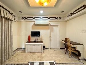 孟买Welcome Home Service Apartments - Andheri的客房设有书桌、桌子和电视。