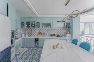 大叻Súp Lơ House (Broccoli's House)的厨房配有白色桌子和蓝色橱柜