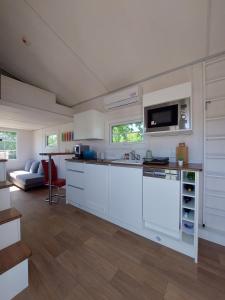 武斯特马克Tiny House Paradies的厨房配有白色橱柜和台面