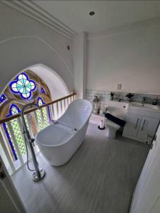 米德尔顿万若Peaceful Church Getaway的带浴缸的浴室和彩色玻璃窗