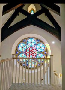 米德尔顿万若Peaceful Church Getaway的教堂楼梯上方的彩色玻璃窗