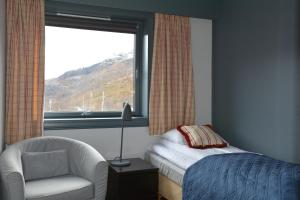 米达尔瓦塔森索酒店的卧室配有床、椅子和窗户。