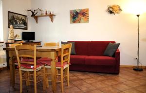 阿贝托内Chalet Abetone in Tuscany的客厅配有桌子和红色沙发