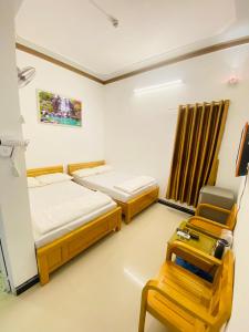 Ninh HảiHotel Aloha 2的一间设有两张床和椅子的房间