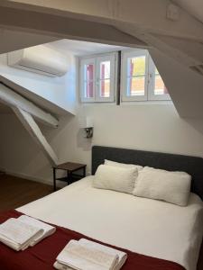 巴约讷Hostel 20 Bayonne的一间卧室配有一张带白色床单和窗户的床。