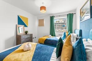 布里斯托Enchanting Bristol Abode -Sleeps 6 with Balcony!的一间卧室设有两张床和窗户。