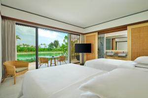 TanjungbingaSheraton Belitung Resort的一间卧室设有两张床,享有湖景