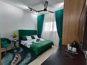 雪邦Lovely Stay By Cinta的一间卧室设有一张绿色的床和一个窗户。