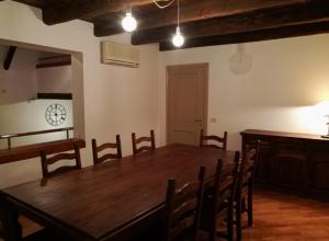 博洛尼亚De' Pepoli Rooms & Apartments的一间带木桌和椅子的用餐室