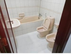 阿布扎比Corniche AD - Stunning Room的浴室配有卫生间、浴缸和水槽。