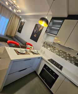 KitweVk apartments的厨房以及带桌椅的起居室。