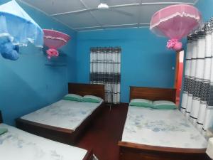 亭可马里阿米拉旅馆的蓝色墙壁客房的两张床