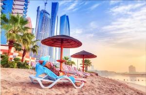 阿布扎比Corniche AD - Stunning Room的海滩上的一组椅子和遮阳伞